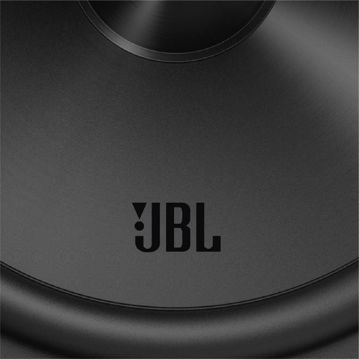 Detailný záber reproduktora JBL, zobrazujúci čiernu membránu s logom JBL v strede.