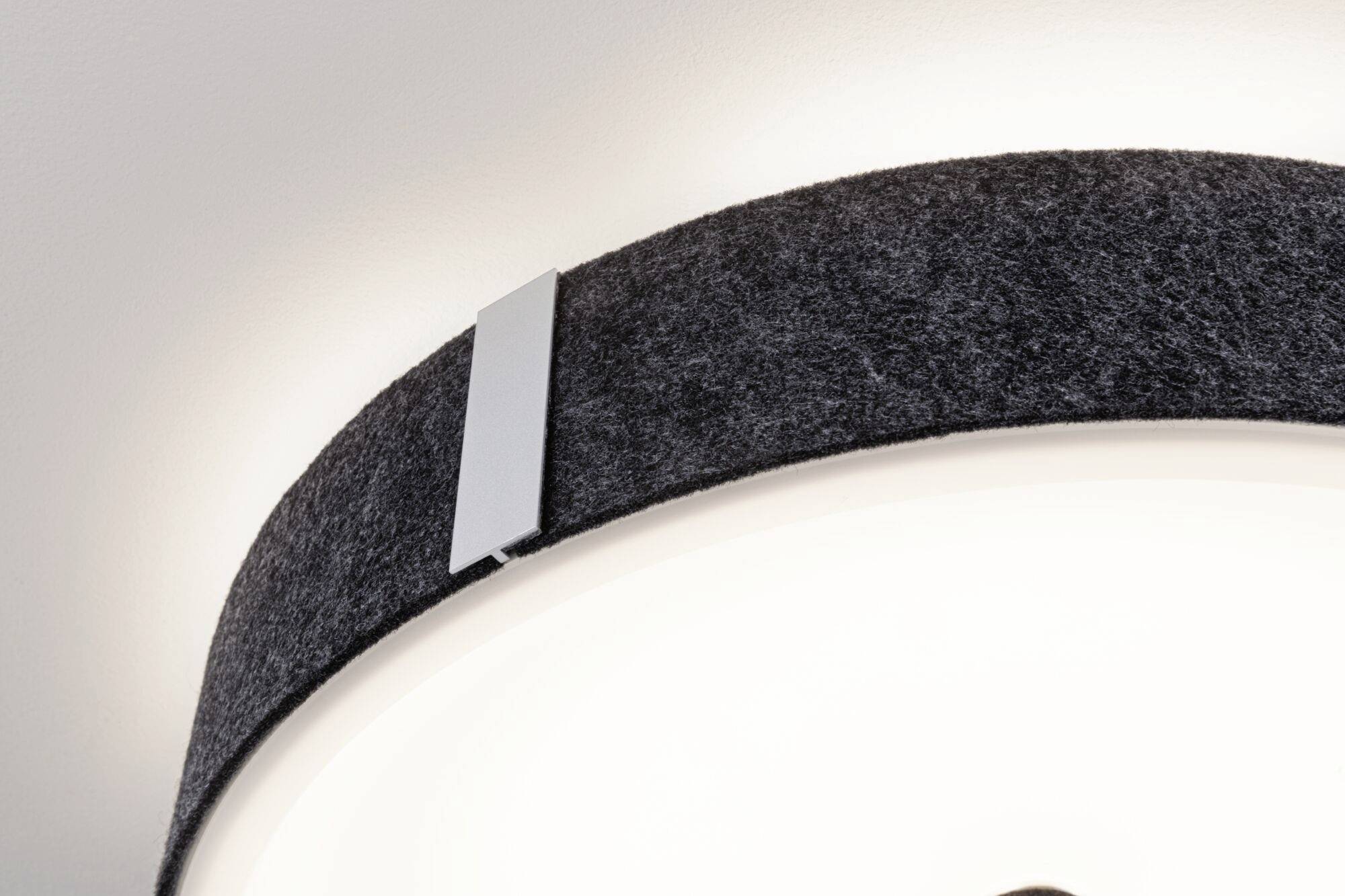 Moderná stropná lampa s okrúhlym čiernym textilným tienidlom a strieborným akcentom, osvetlená zvnútra.