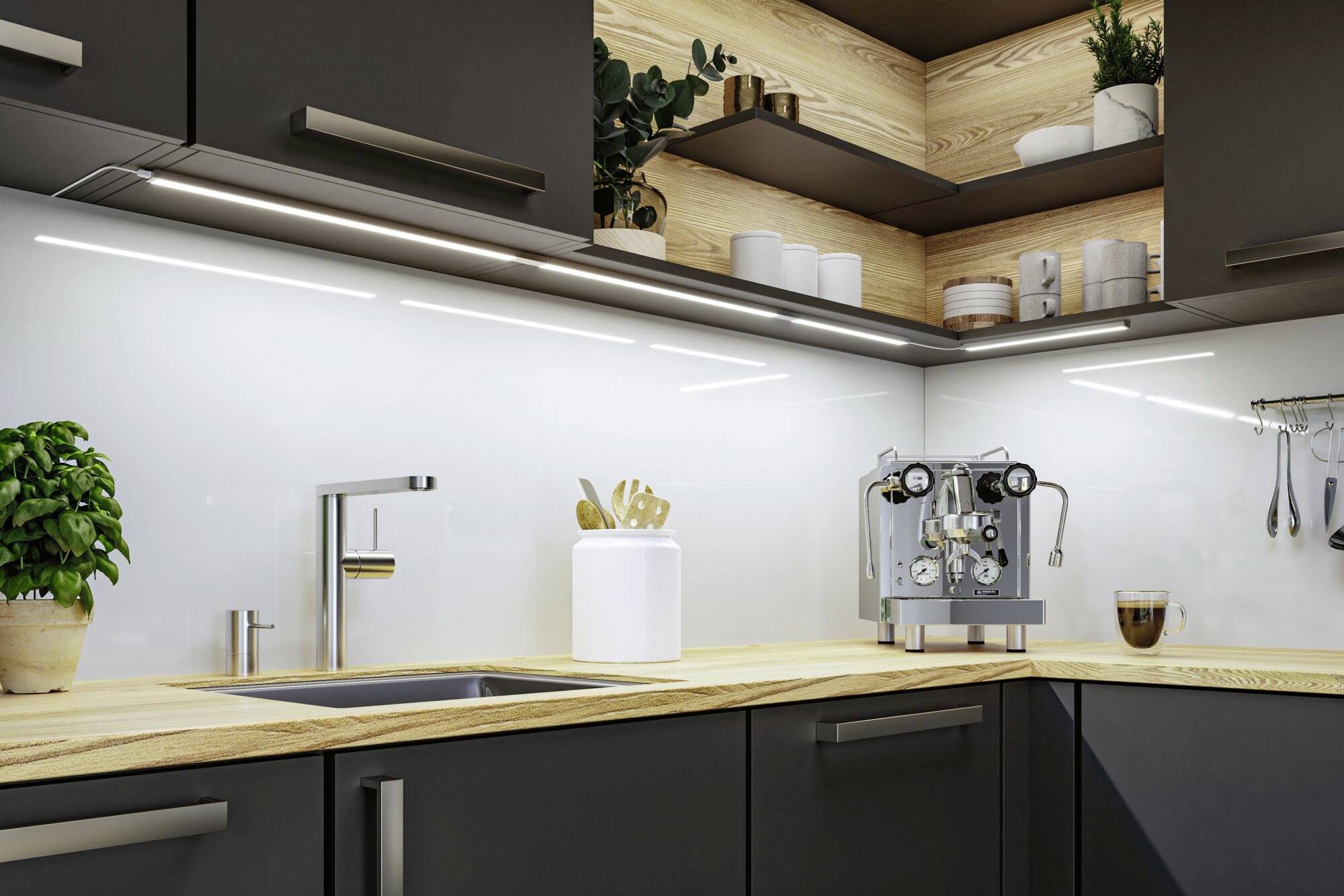 Moderná kuchyňa s tmavými skrinkami, drevenou doskou a osvetlením. Kávovar, rastliny a kuchynské potreby na pracovnej doske.