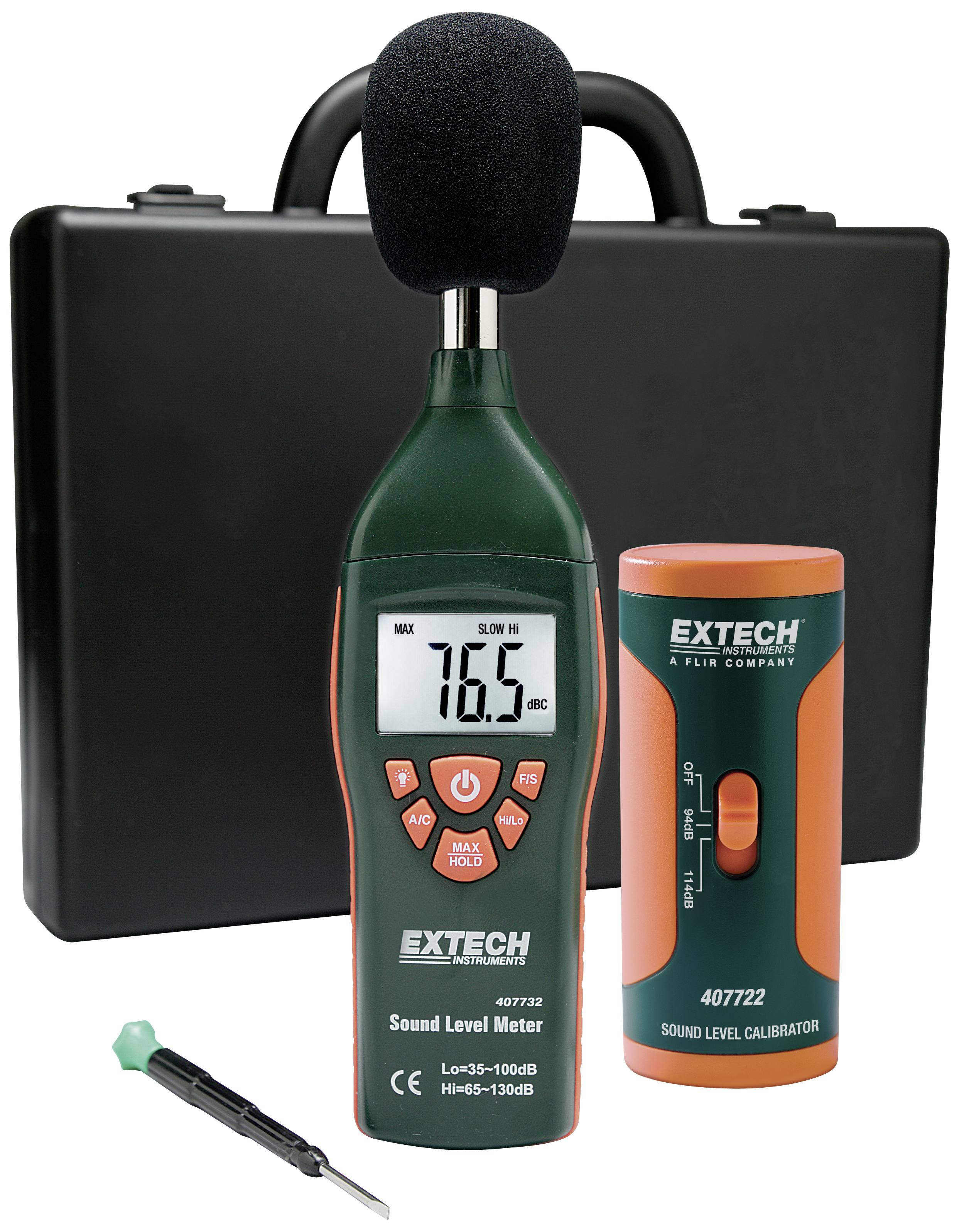 'Extech' prístroj na meranie hladiny zvuku s displejom zobrazujúcim 76,5 dB. Súčasťou balenia je kalibrátor, skrutkovač a čierny kufor v pozadí.