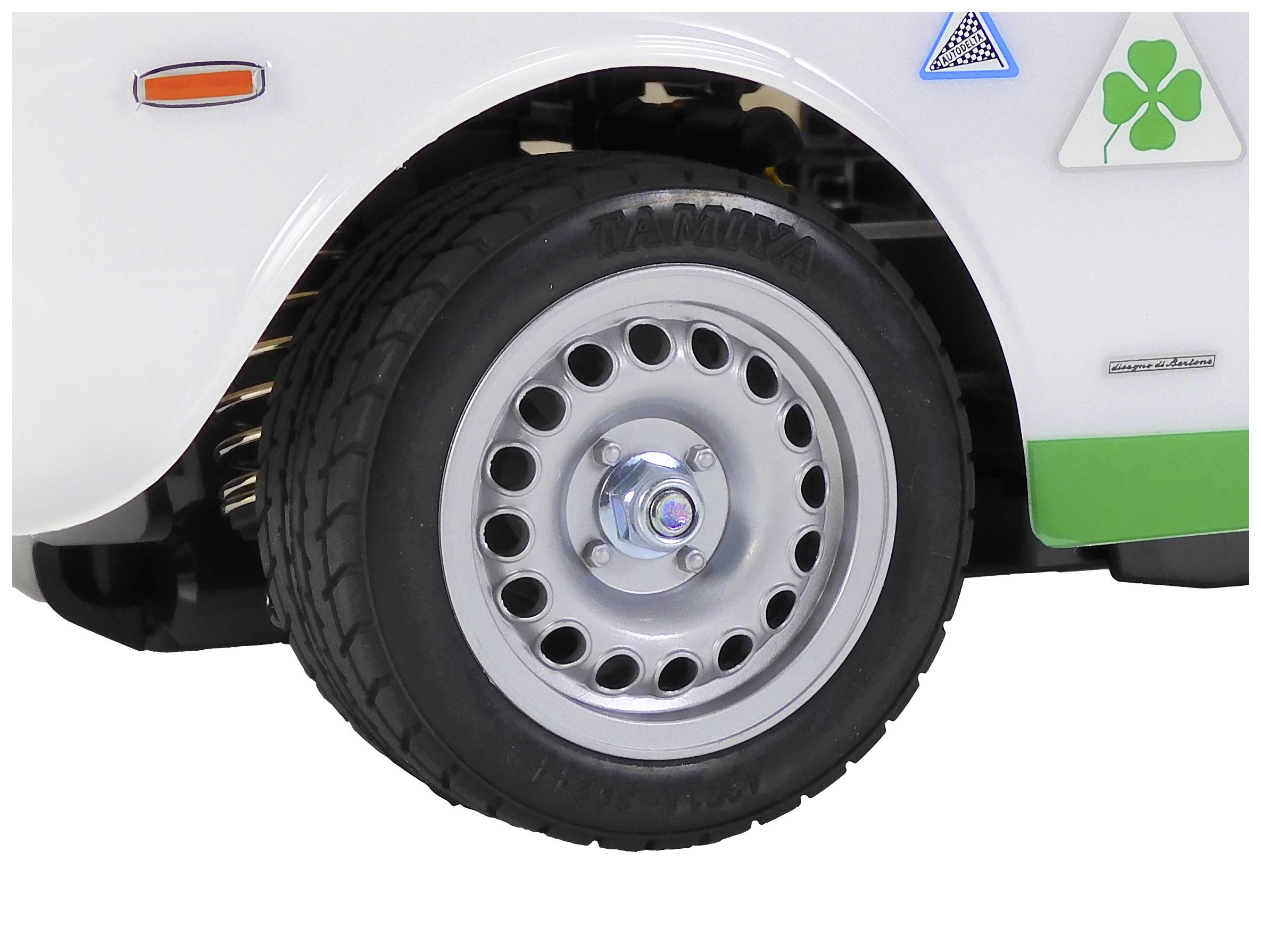 Predná časť bieleho vozidla s pneumatikou a ráfikom. Je viditeľné zelené emblémové logo štatul'ku.