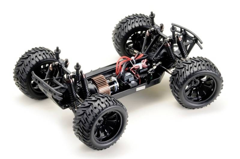 RC autošasi so štyrmi veľkými terénnymi pneumatikami, viditelnými tlmičmi a elektromotorom s prepojovacími káblami.