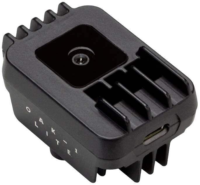 Čierna elektronická kamera s nápisom 'OAK-1 Lite' na kryte, zobrazujúca skrutkovú prírubu a USB port.