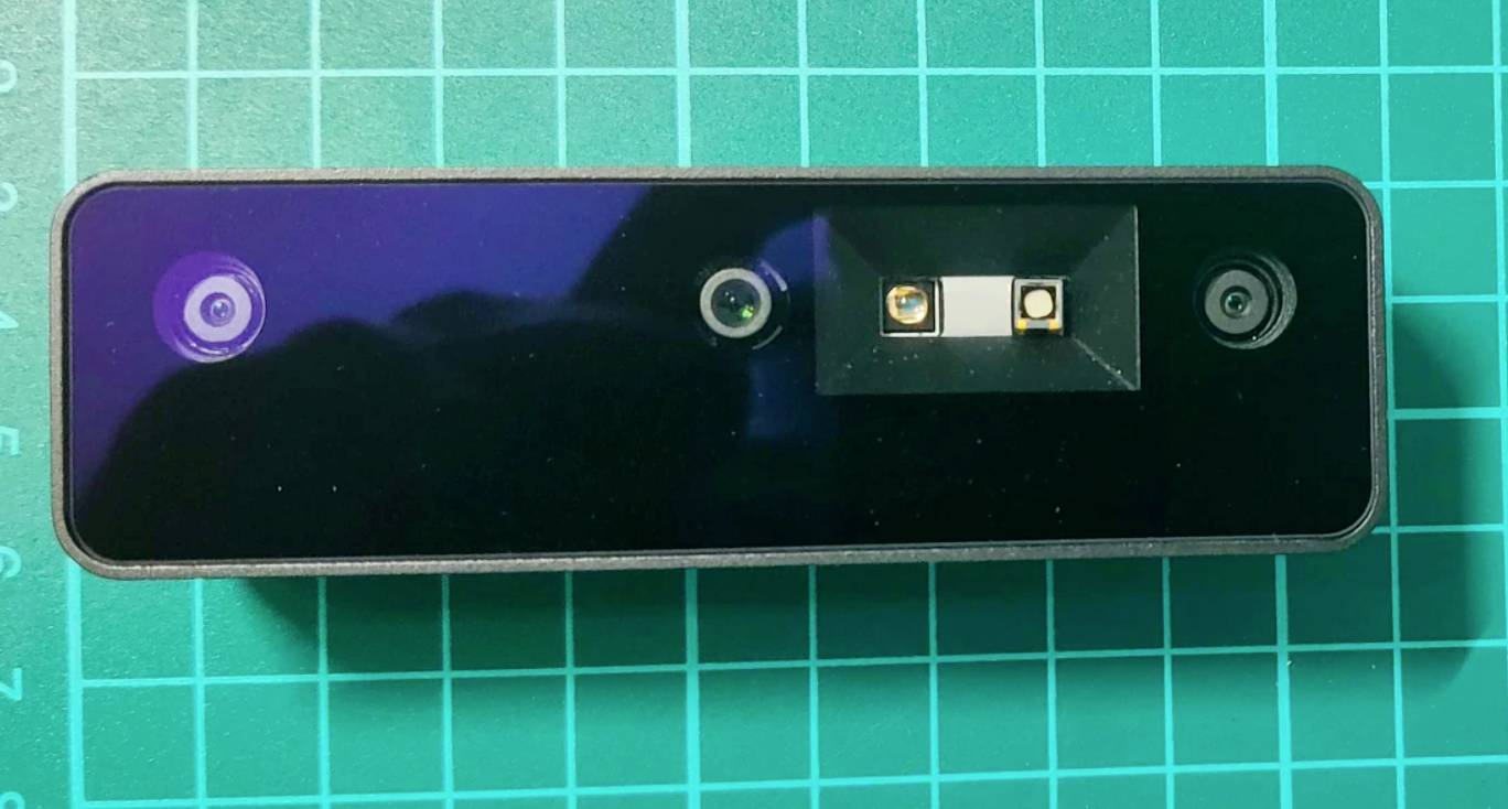 3D senzor umiestnený na zelenej reznej podložke je centrálne zarovnaný s kamerovými šošovkami a hĺbkovým senzorom.