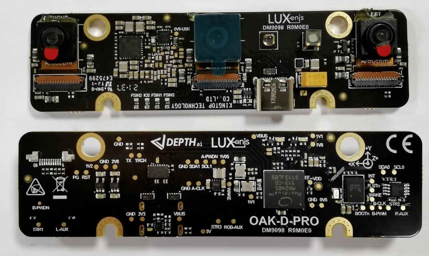 Dve úzke dosky plošných spojov s elektronickými komponentmi a kamerovými modulmi, označené nápismi 'OAK-D-PRO' a 'LUXonis'.