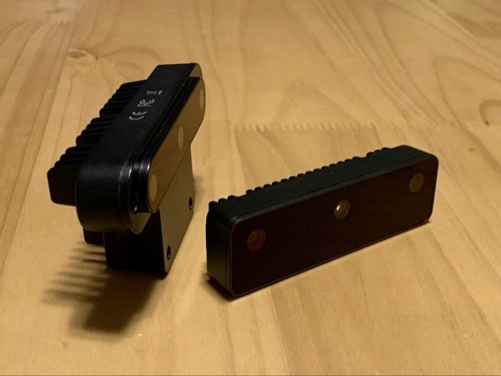 Dva čierne elektronické moduly s upevňovacími otvormi na drevenom stole, vhodné pre technické aplikácie alebo DIY projekty.