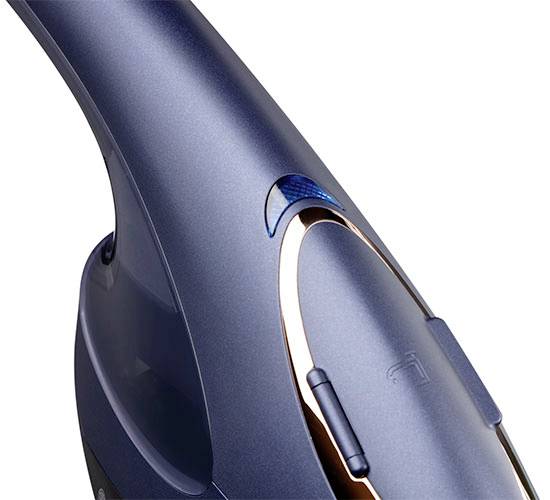 Detailný záber moderného bezdrôtového vysávača v tmavej modrej a medenej farbe s ergonomickou rukoväťou a elegantnými líniami.