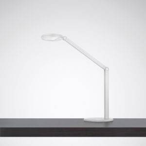 Moderná biela stolová lampa s elegantným dizajnom stojí na tmavom stole. Rameno lampy je ohnuté v uhle.