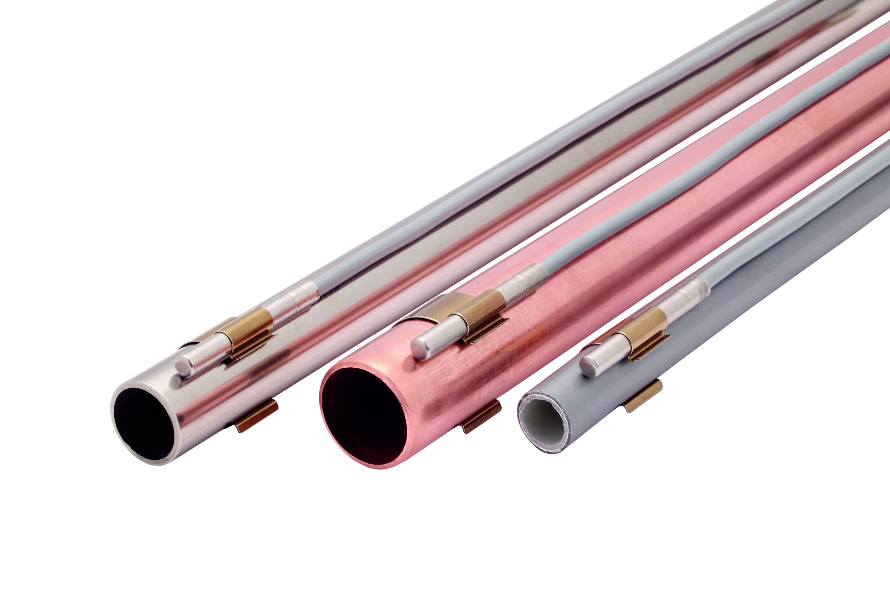 Tri kovové rúry rôznej veľkosti a farby, každá s pripevneným medeným drôtom na povrchu.