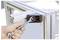 Ruka používa kľúč na dotiahnutie skrutky na rohovom spoji kovového rámu, čo ukazuje výstavbu alebo montáž konštrukčného rámu.