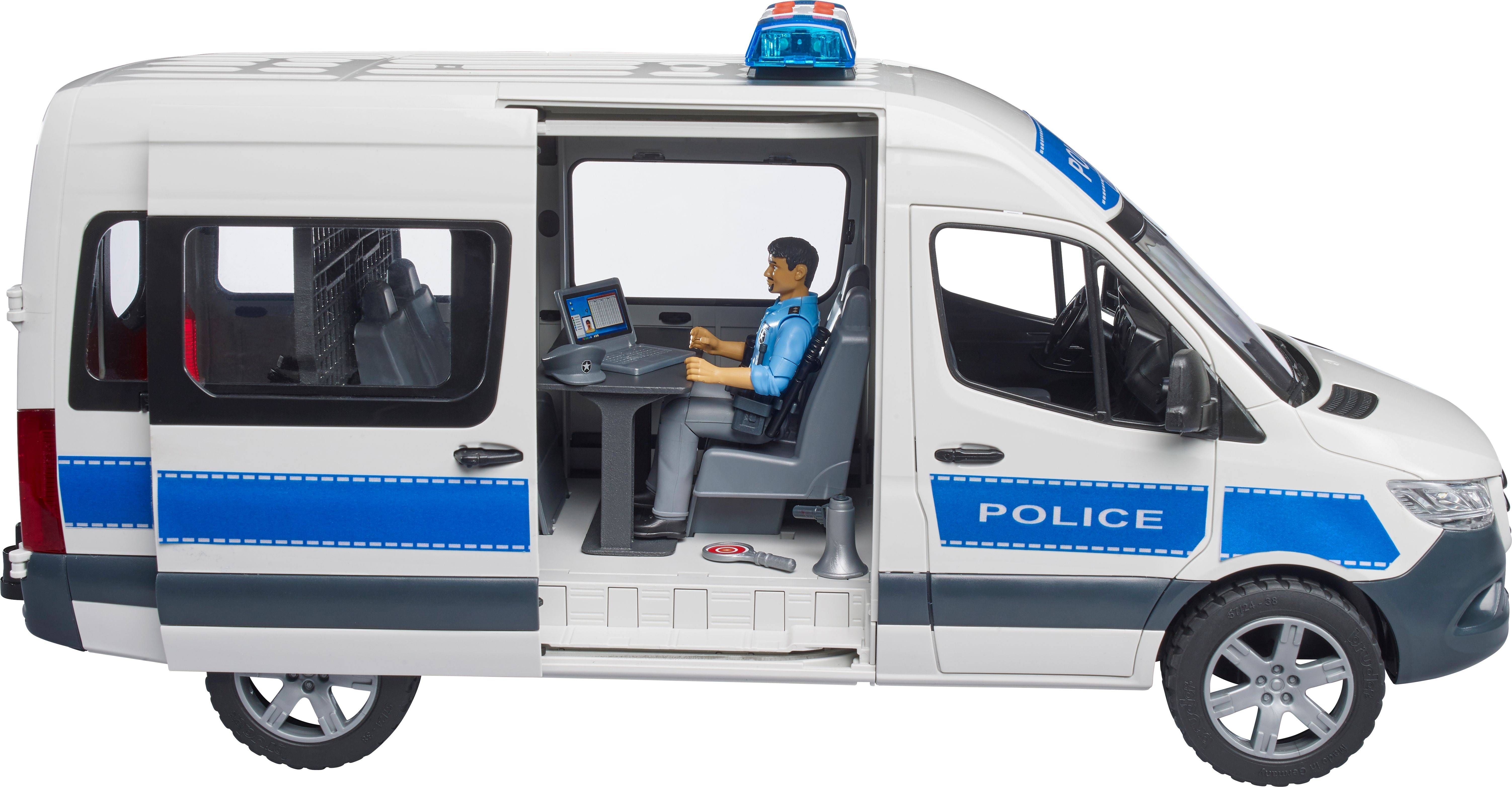 Hračkársky policajný transport s otvorenými dverami ukazuje policajta vo vnútri, ktorý sedí pri laptope.