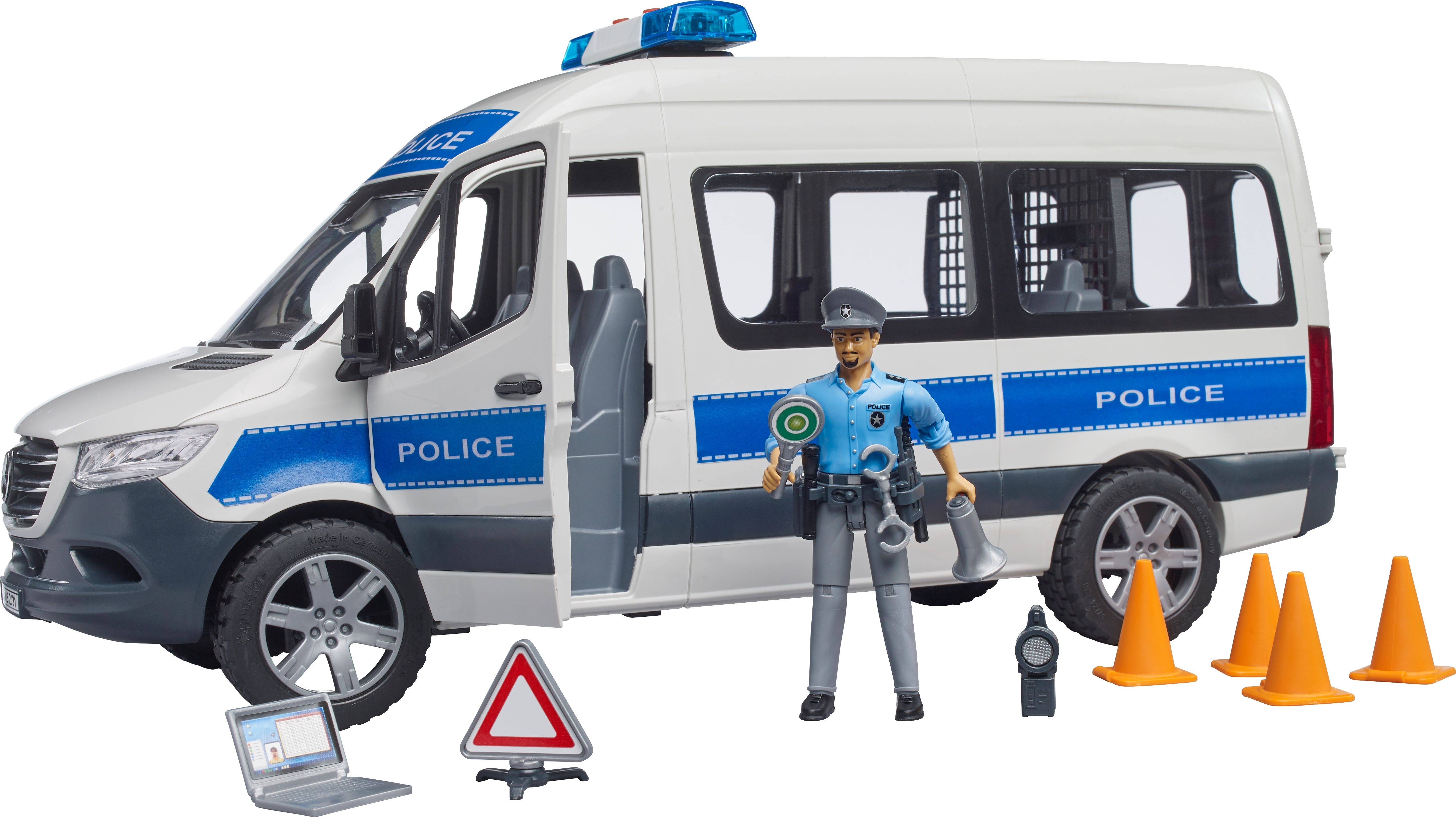 Hračkársky policajný dodávkový automobil s figúrkou, dopravným kužeľom, laptopom a dopravnou značkou. Dodávka má nápis 'Police'.