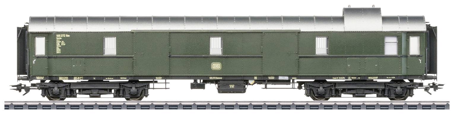 Zelený nákladný vagón so striebornou strechou stojí na koľaji. Vagón má niekoľko dverí a okien po stranách.