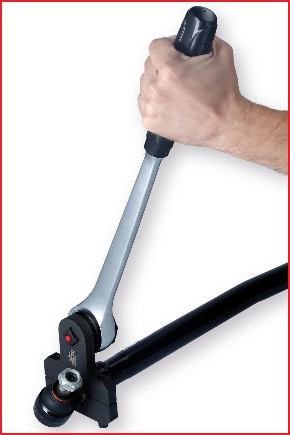 Ruka drží mechanický nástroj s pákou, pravdepodobne hydraulické rezacie zariadenie na skrutky.