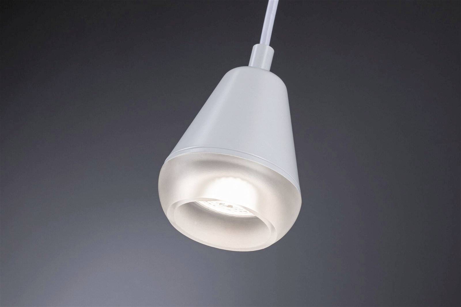 Zavesená biela lampa s moderným dizajnom pred tmavosivým pozadím, svieti jasne.