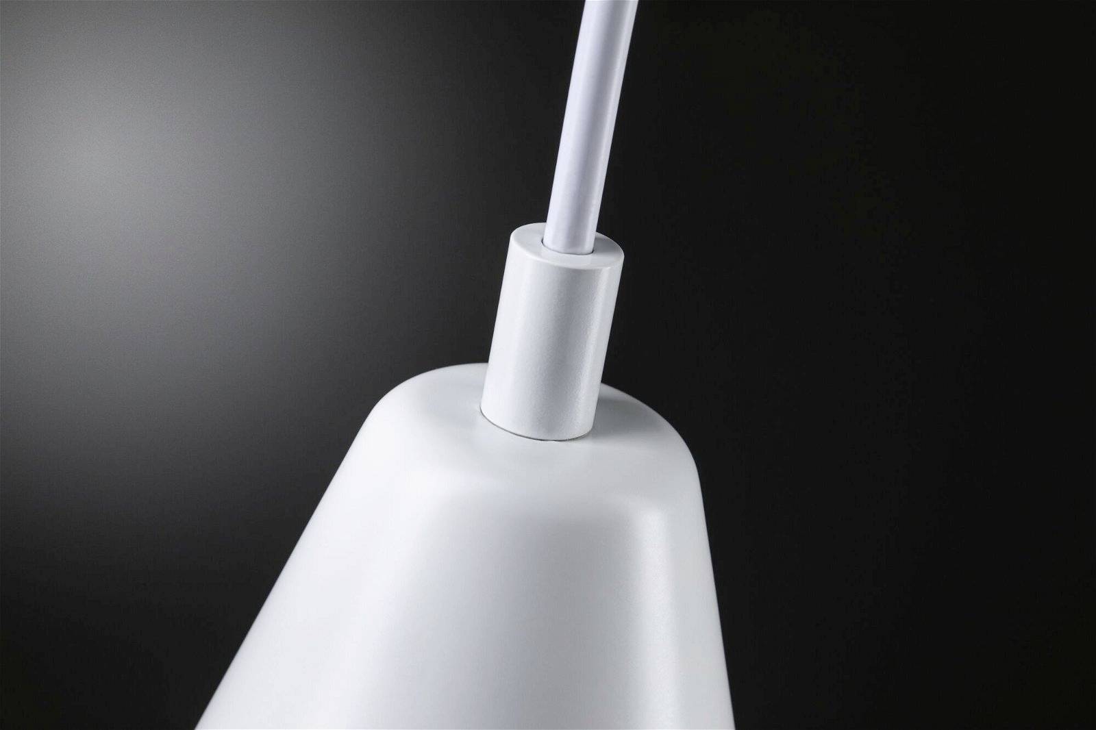 Závesná lampa s bielym tienidlom pred čiernym pozadím.