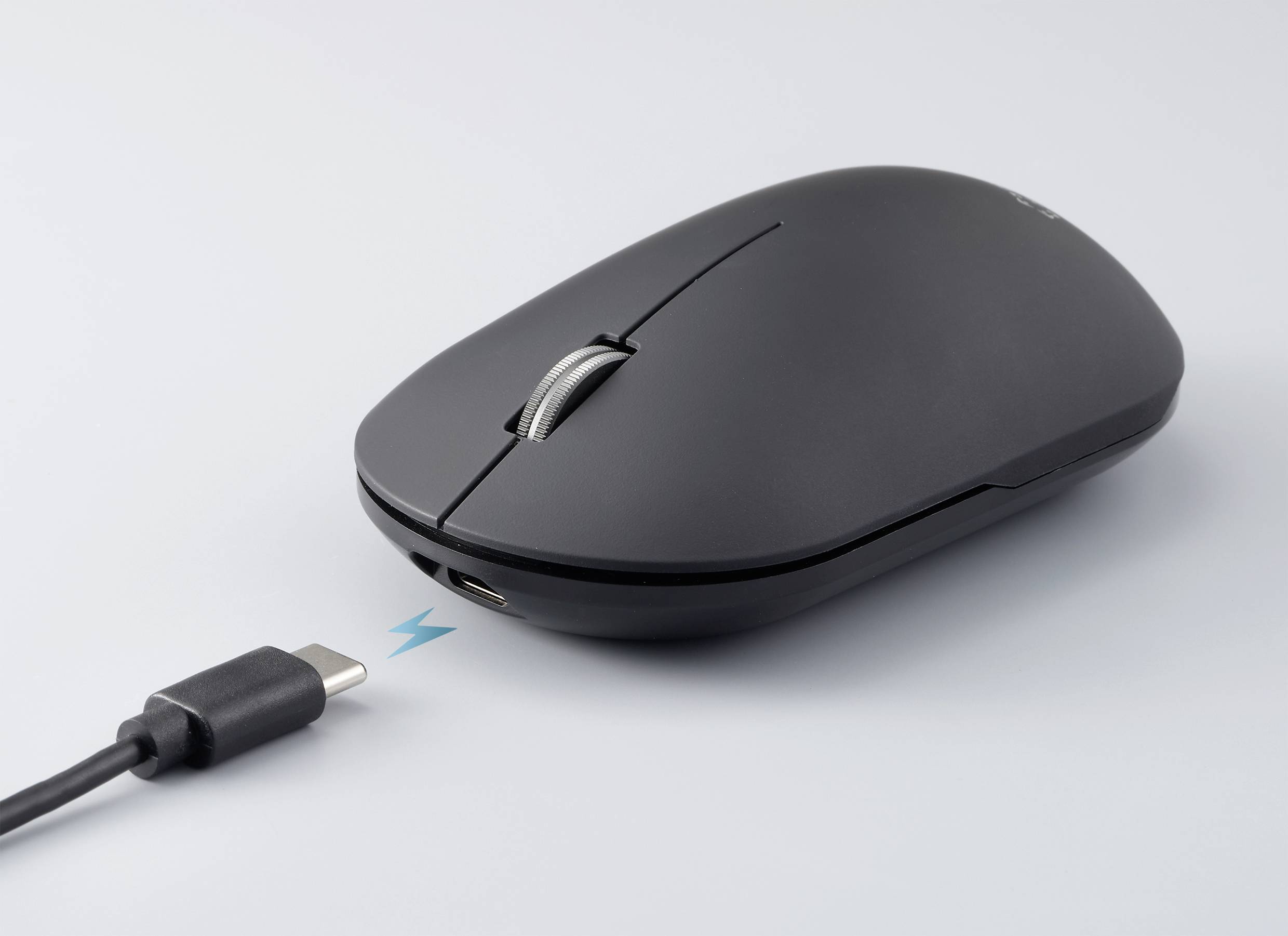 Čierna počítačová myš s USB-C nabíjacím káblom, ktorý je pripojený k myši; symbolizuje nabíjanie myši.