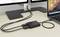 USB hub prepája laptop s dvoma monitormi na pracovnom stole. Káble sú vedené upravene pozdĺž pracovnej plochy.