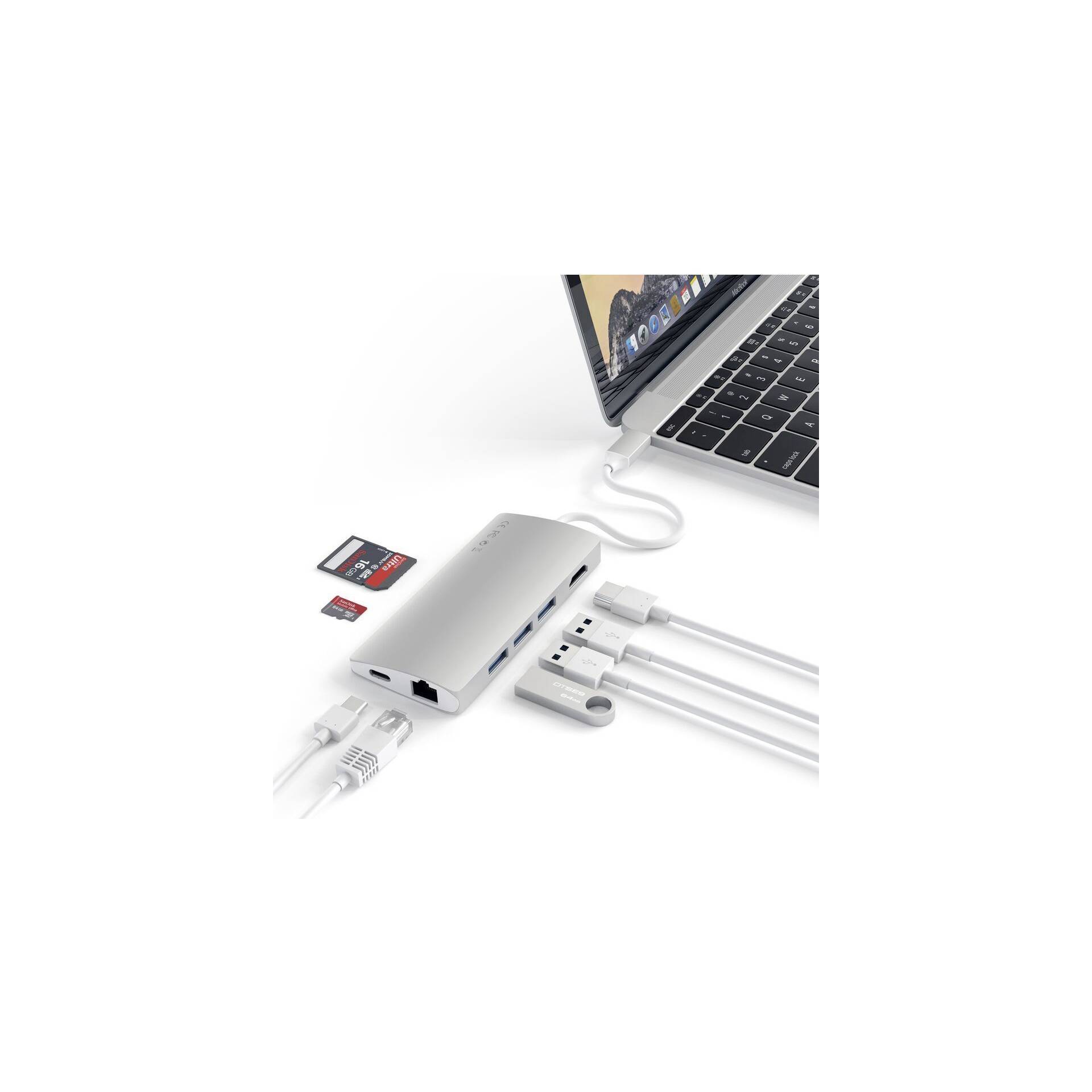 Laptop s pripojeným USB-C hubom. Na hub sú pripojené rôzne káble a pamäťové karty.