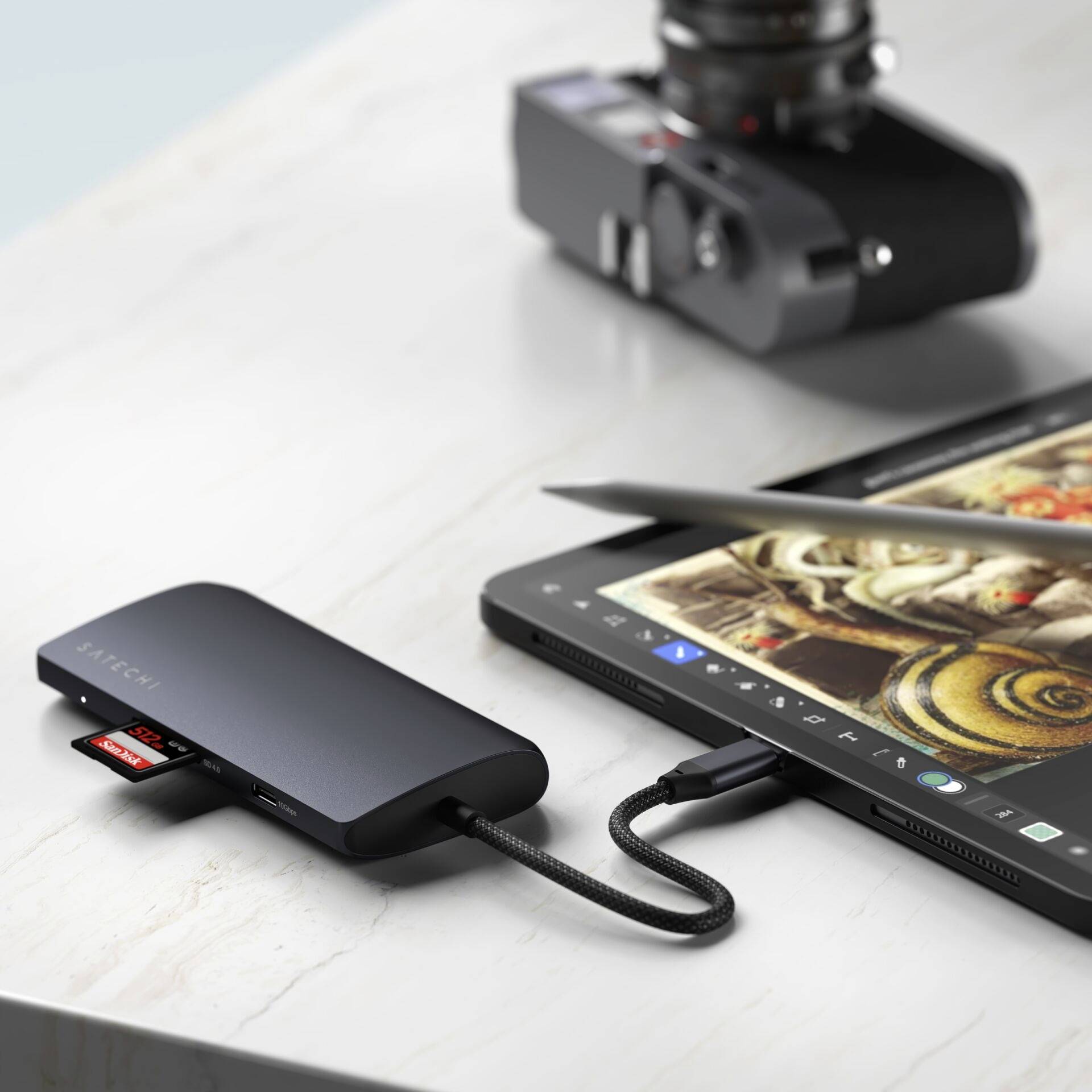 Čierny USB-C hub spája kameru a tablet. Na tablete je vidieť umeleckú kresbu.