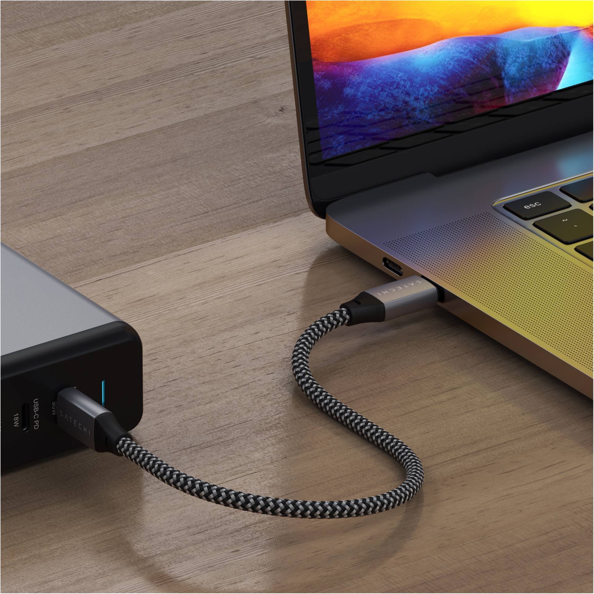 Laptop je pripojený k externého disku cez opletený USB-C kábel.