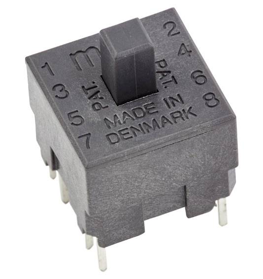 Čierny elektromechanický spínač s otočným regulátorom, označený nápisom 'MADE IN DENMARK', čísla 1-8 obklopujú základňu spínača.