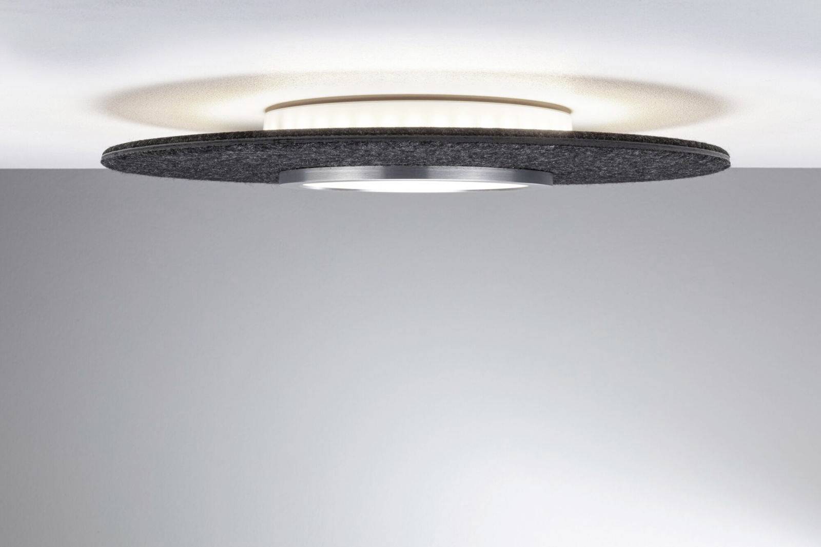 Guľaté, moderné stropné svietidlo s čiernym rámom a jemným, difúznym svetlom, ktoré jemne vyžaruje na strop.