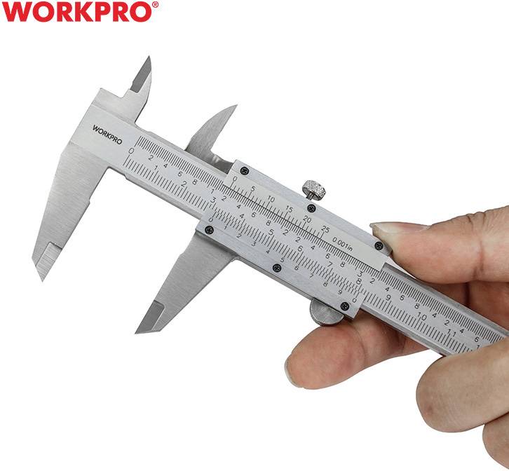 Jedna ruka drží strieborný posuvný meter s milimetrovou stupnicou v blízkosti loga "WORKPRO", pripravená na meranie.