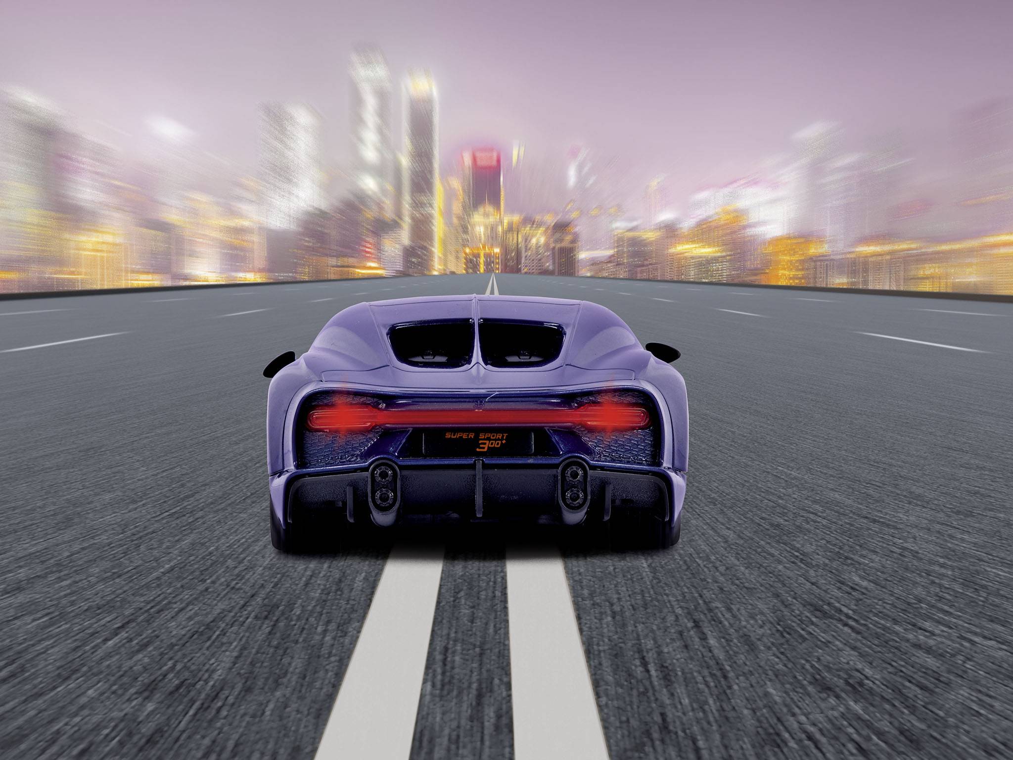 Fialový sportový automobil rýchlo jazdí na prázdnej ceste. V pozadí sú rozmazané svetlá mesta.