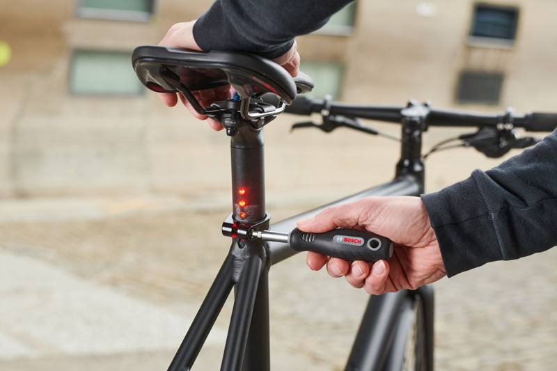 Osoba si pomocou momentového kľúča Bosch uťahuje sedlovku bicykla, aby zabezpečila správnu výšku sedla.