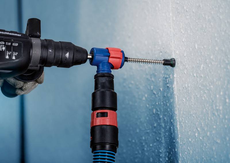 Vŕtačka s vrtákom, ktorý vŕta do steny. Skrutka sa zaskrutkuje do navŕtaného otvoru.