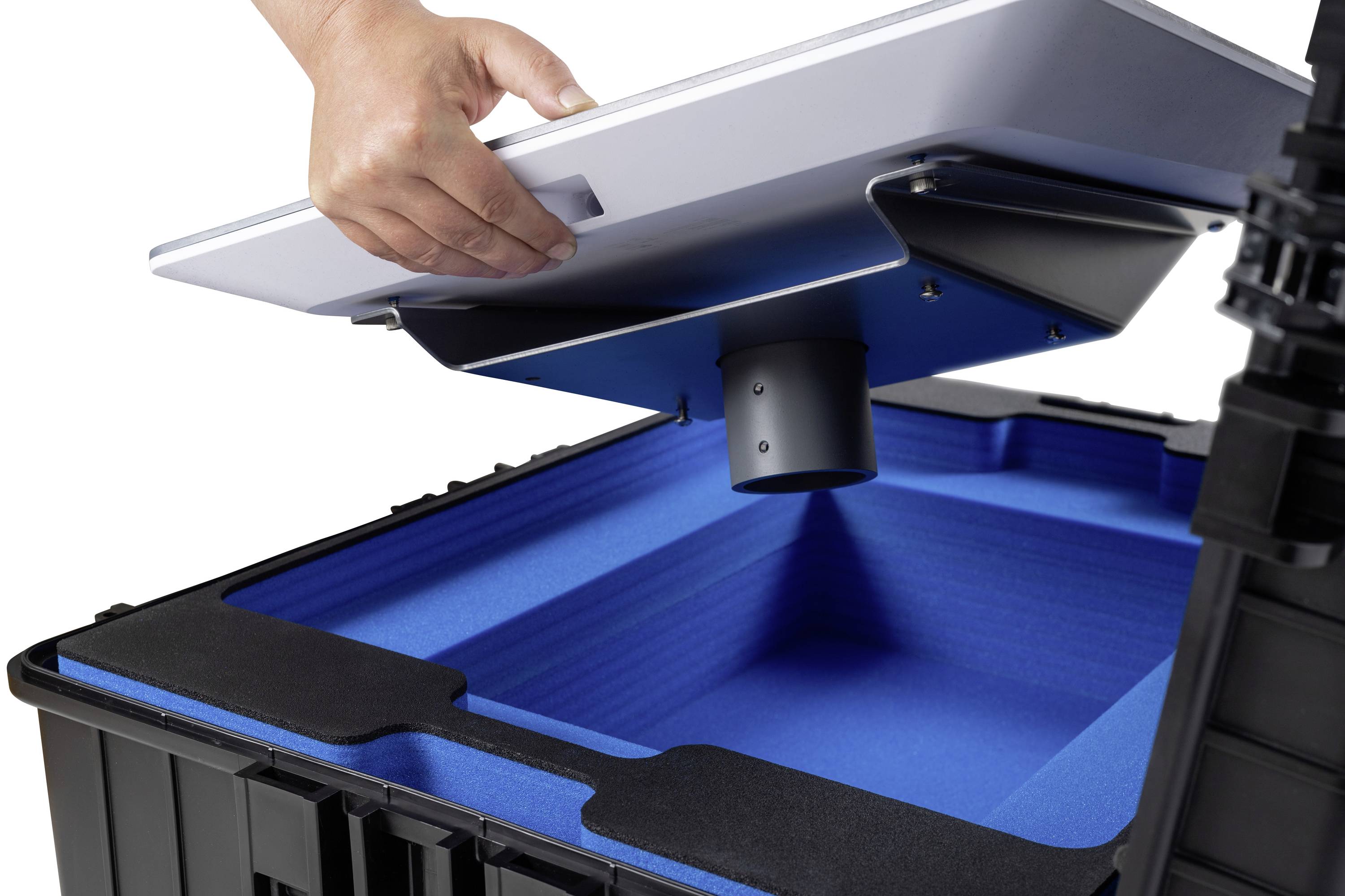 Osoba dvíha veko modrej prepravnej krabice s šedým vnútorným uzáverom. Krabica má hrubé penové výstelky.