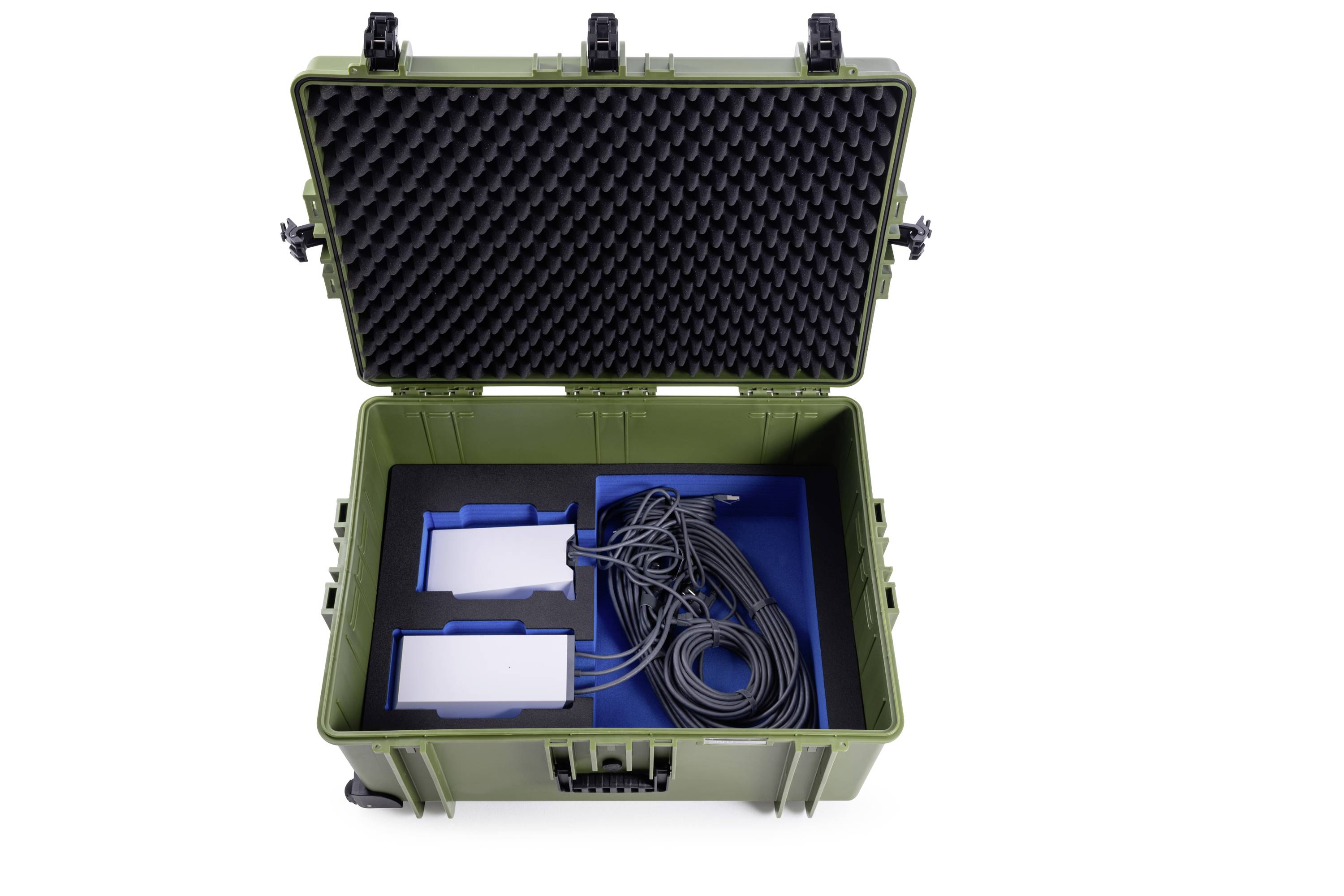 Zelený otvorený kufor s penovou výplňou odhaľuje káble a dva biele zariadenia v modrých držiakoch.