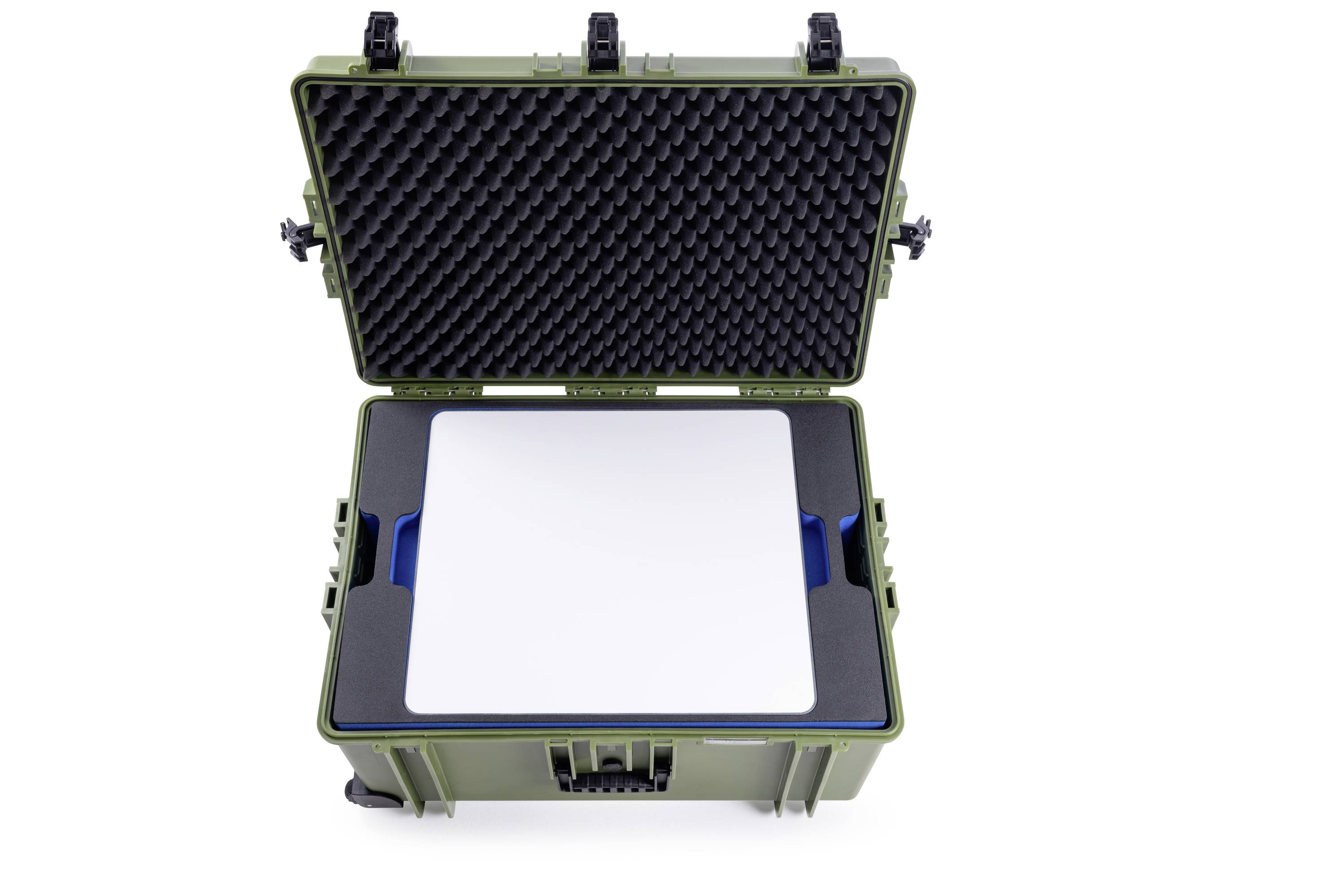 Otvorený zelený tvrdý kufor s penovou výplňou. Vnútri leží obdĺžnikové biele zariadenie alebo vložka pre objekty.