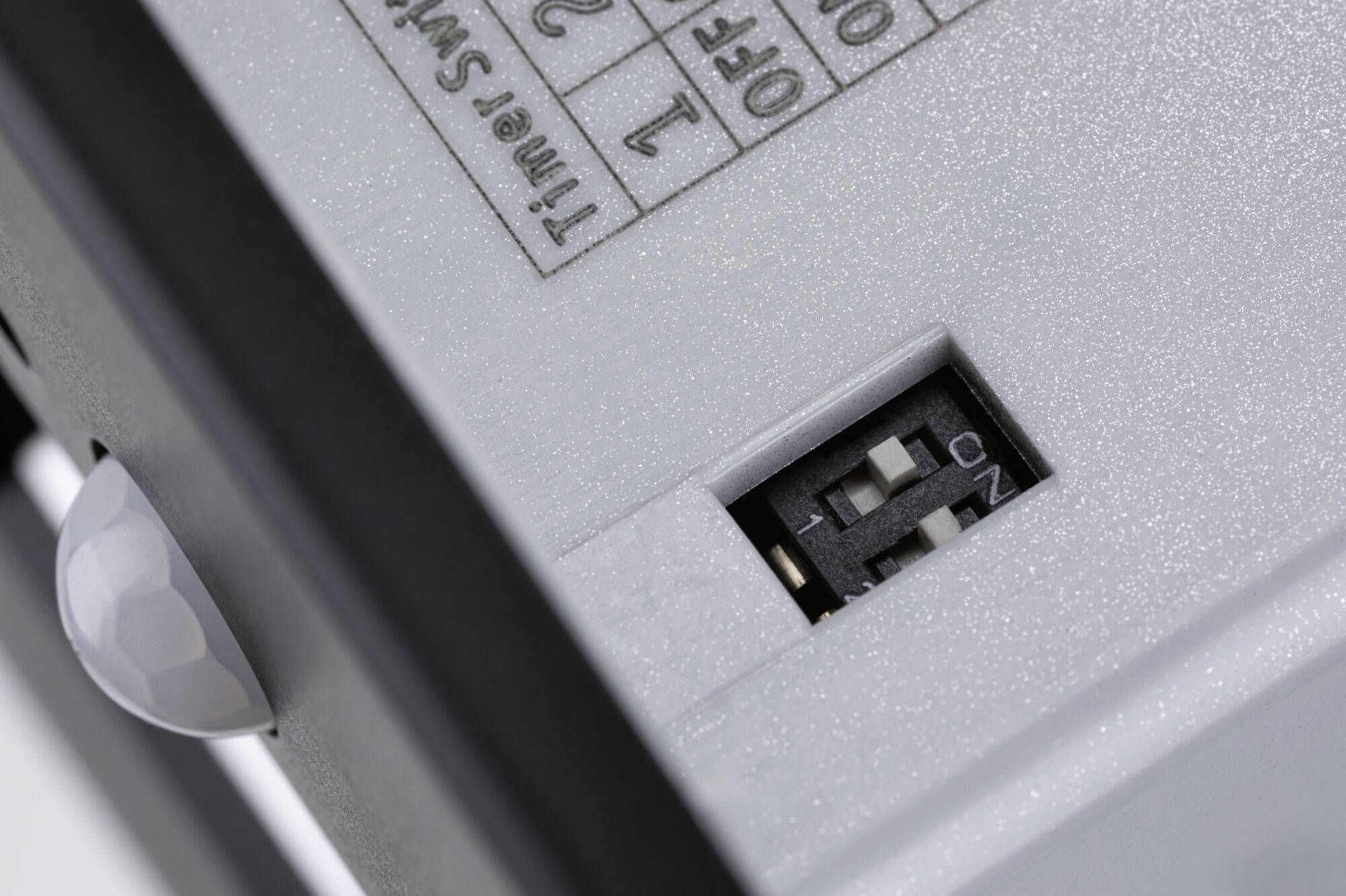 Detailný záber prepínača s dvoma polohami, 'ZAP' a 'VYP'. Vedľa neho je ďalší prepínač s číslami 1 a 2.