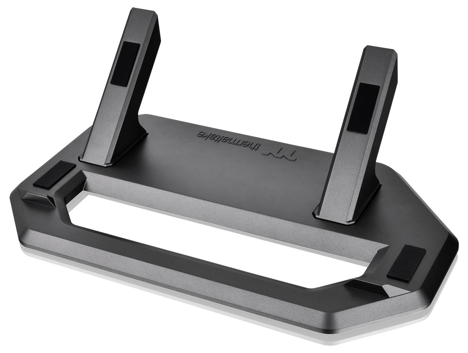 Na obrázku je čierny stojan na notebook. Má dva sklopiteľné ramená a obdĺžnikovú základňu s lesklým povrchom.