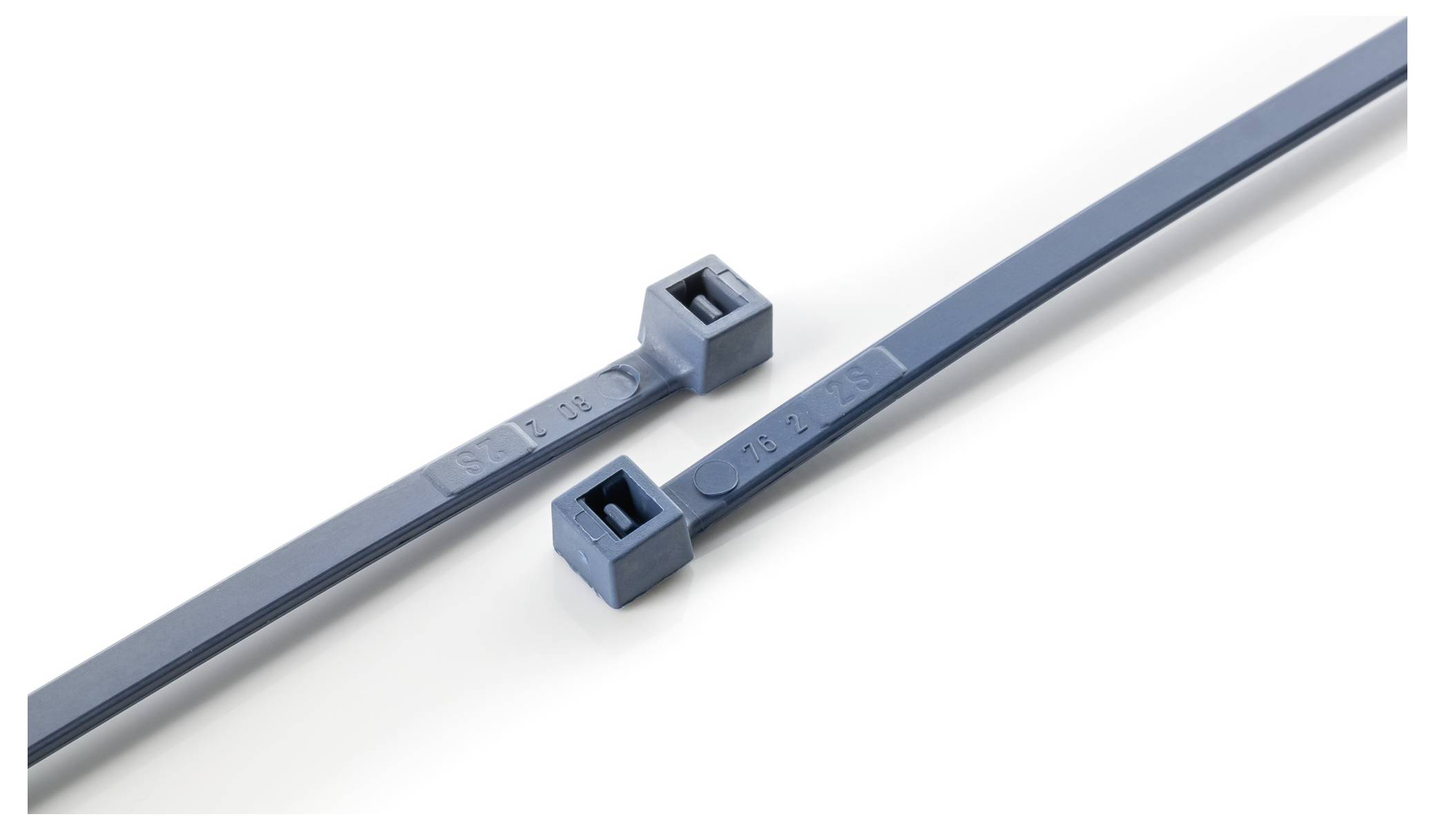 Dva modré plastové sťahovacie pásky ležiace vedľa seba na bielom povrchu. Na ich koncoch sú obdĺžnikové spojovacie mechanizmy.