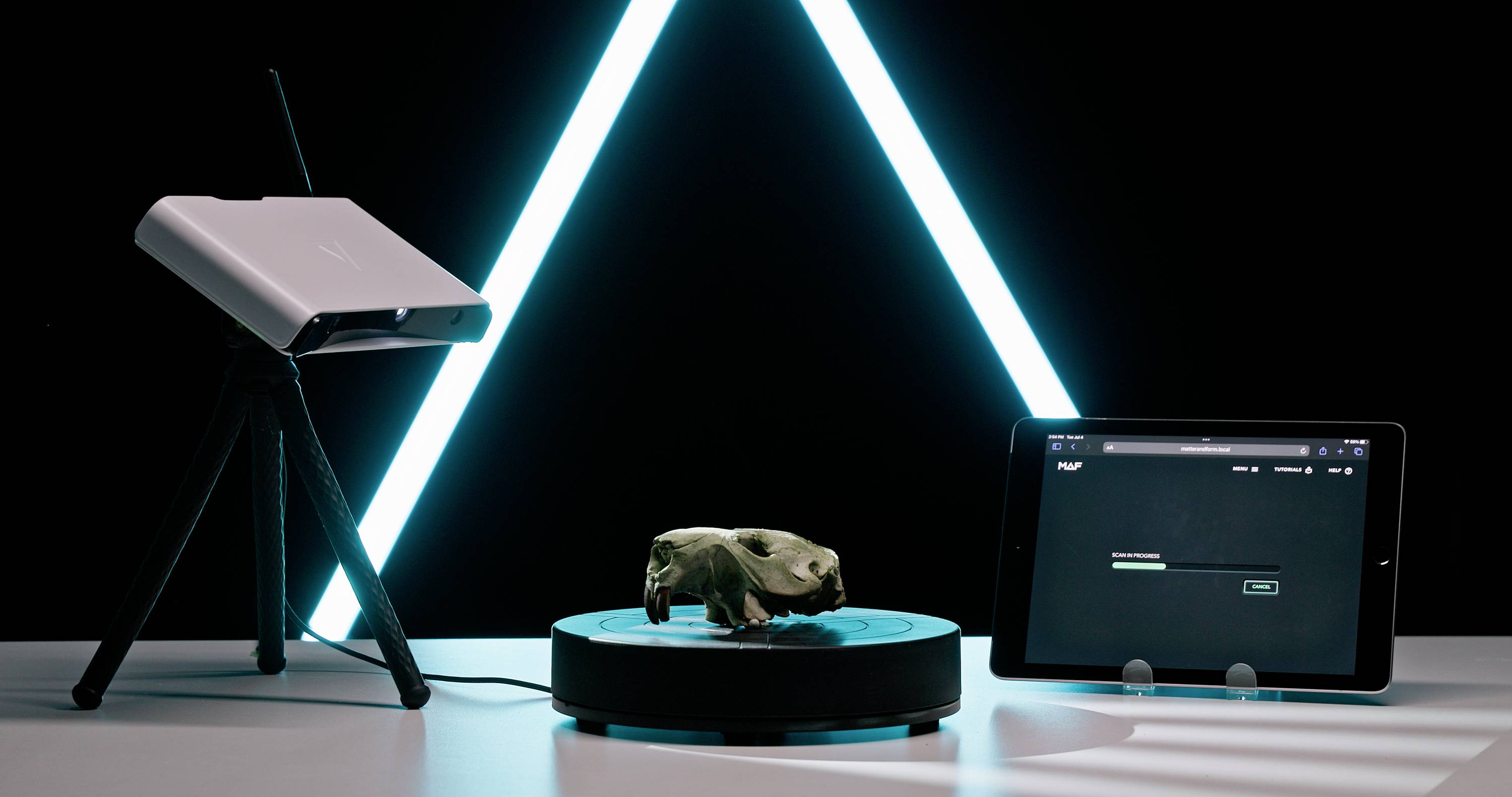 Skener digitalizuje malý objekt na otočnom stole, pričom výsledky sú zobrazované na tablete v pozadí.