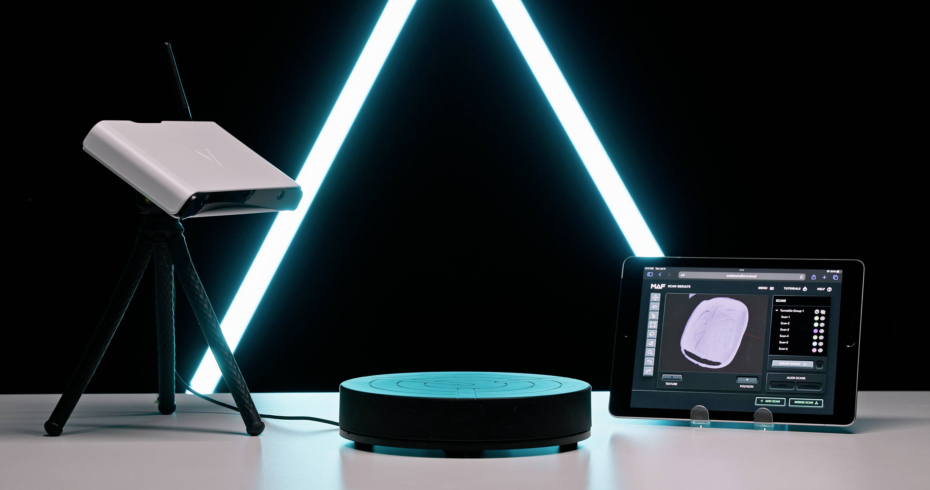3D skener na stative sníma objekt na otočnom tanieri; tablet zobrazuje naskenovaný 3D model.