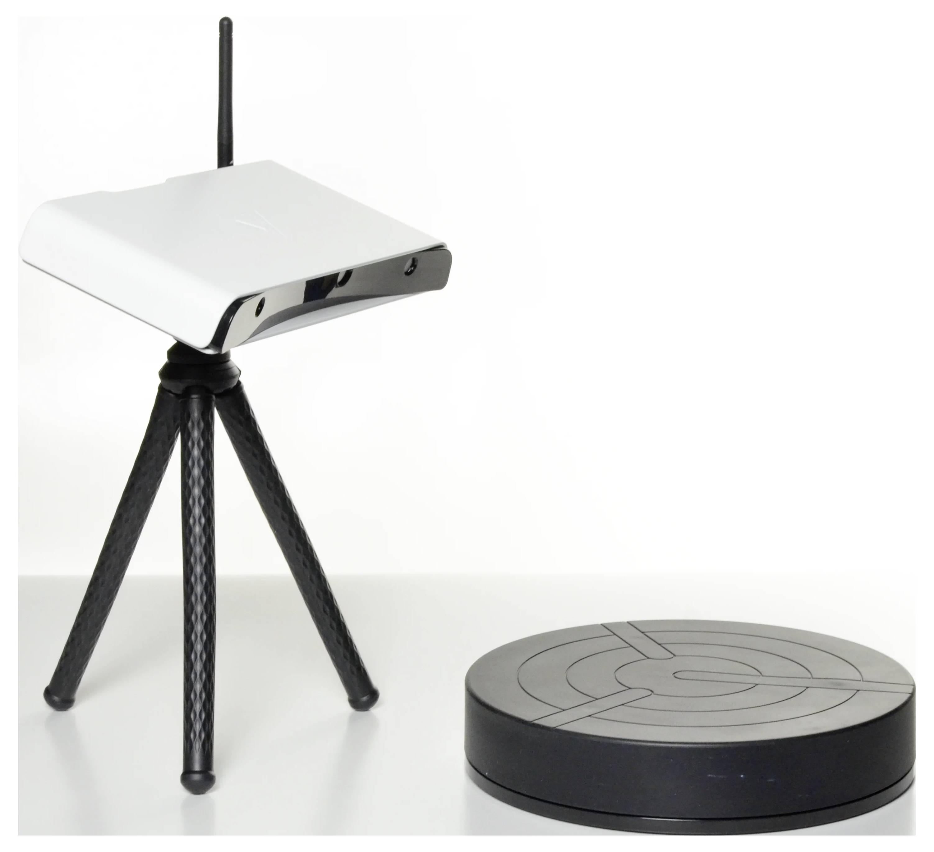 Biely Wi-Fi router na stojane vedľa čiernej okrúhlej základnej stanice na stole.