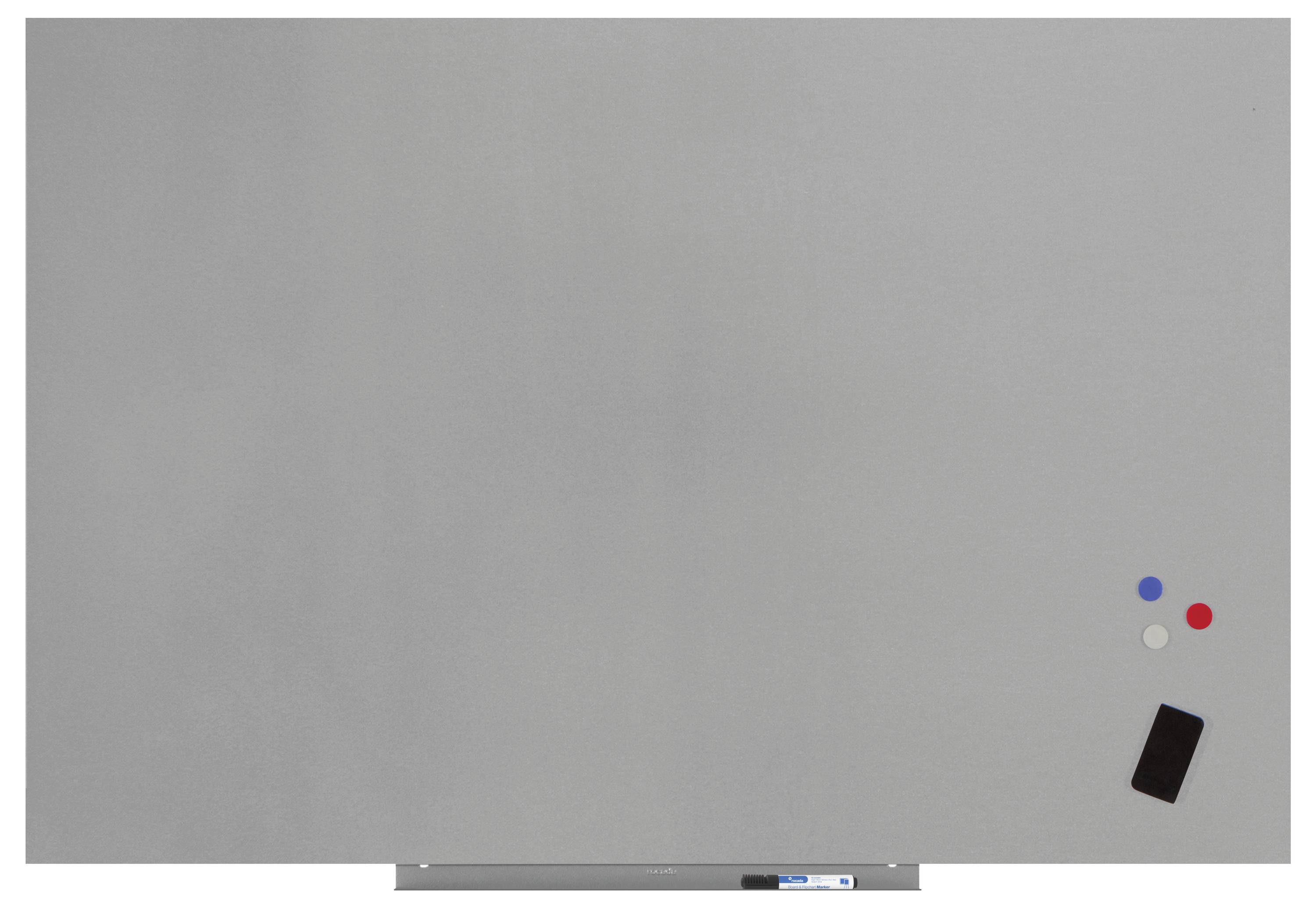 Pohľad na kapitolu whiteboard-u s tromi magnetmi (modrý, biely, červený) a čiernym objektom, pravdepodobne gumou.