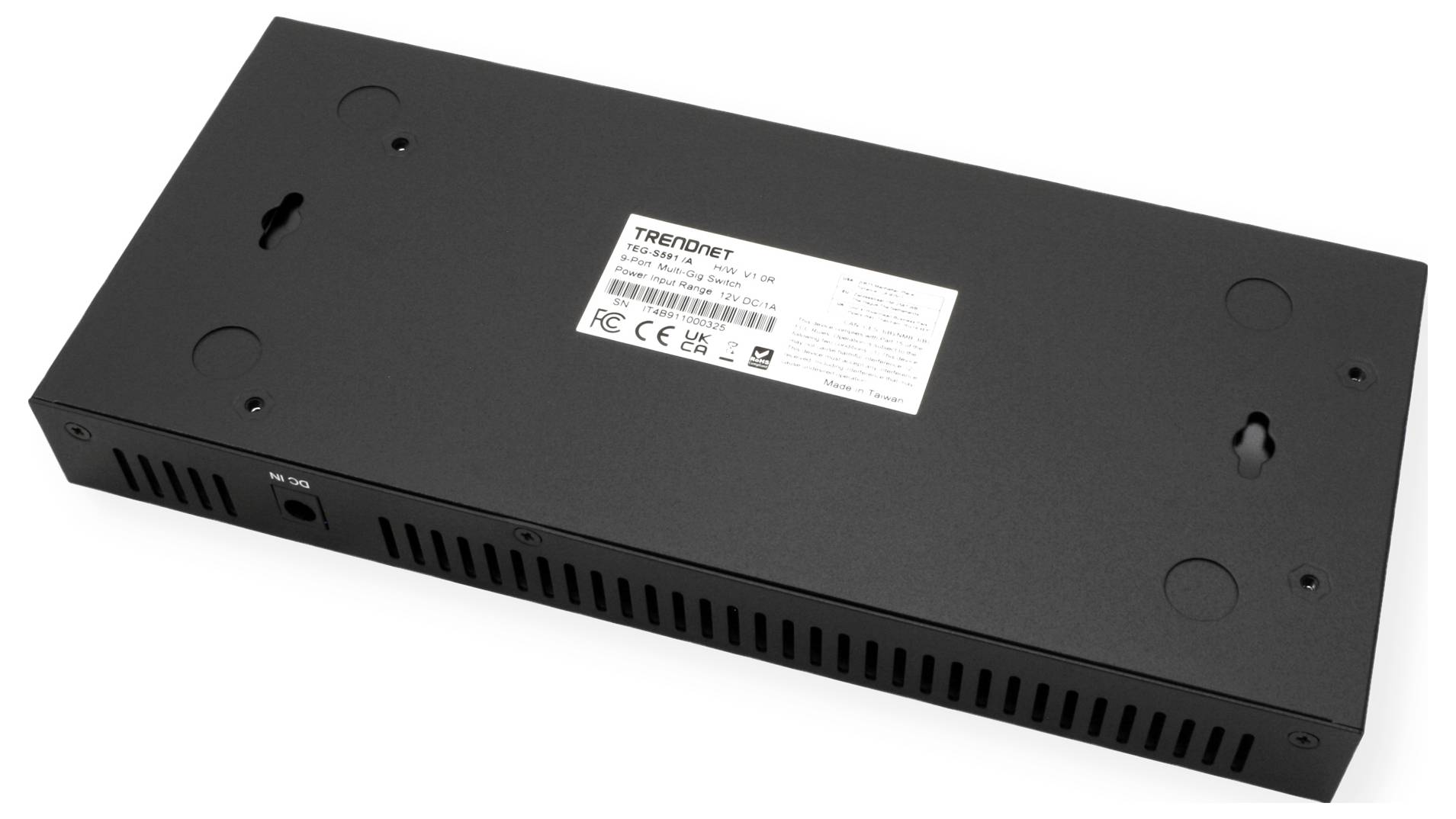 Čierne, obdĺžnikové sieťové zariadenie (TRENDnet) s upevňovacími bodmi a vetracími štrbinami. Zadná strana zobrazuje číslo modelu a certifikácie.