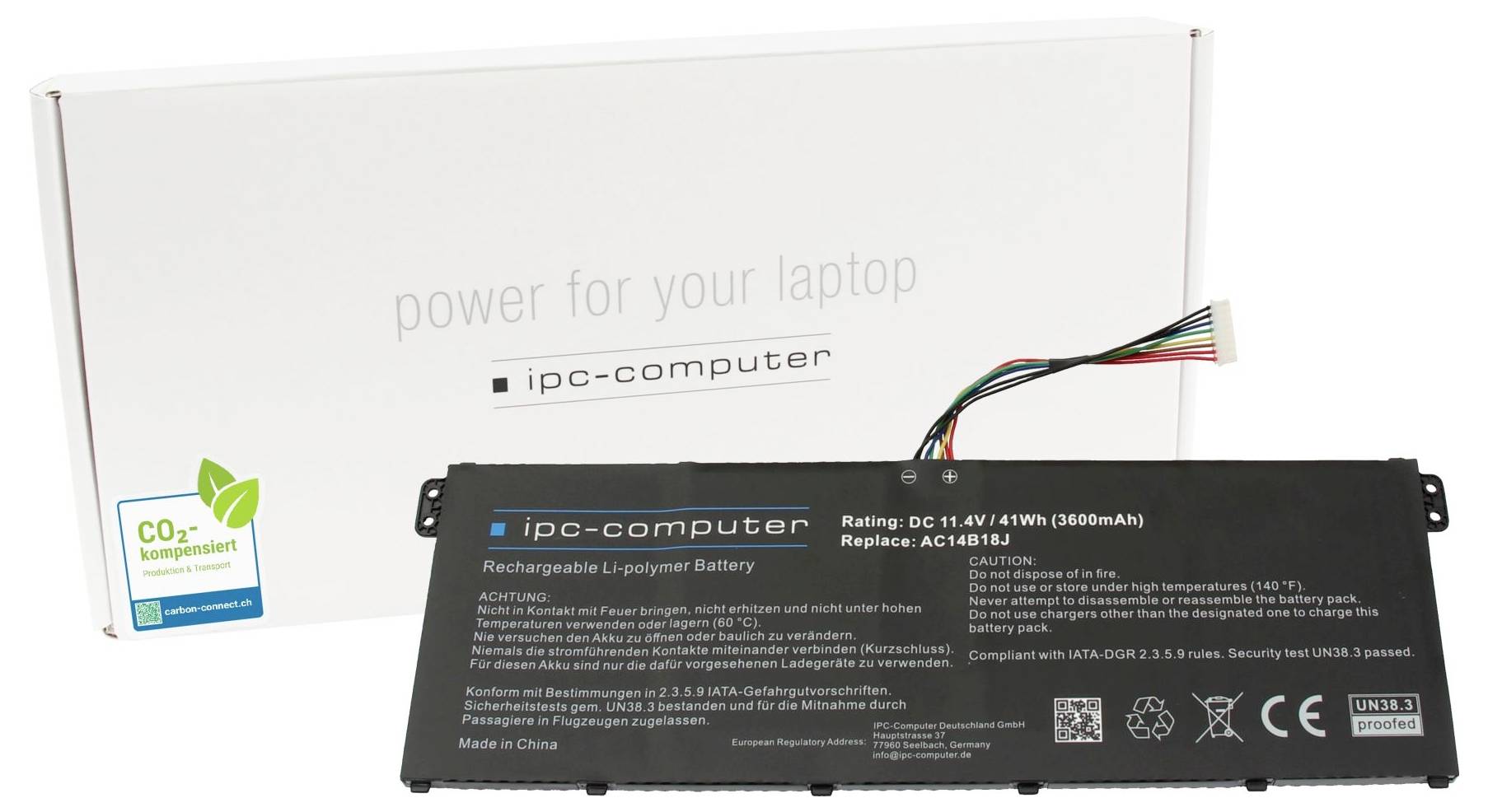 Čierny laptop batériu od 'ipc-computer' pred bielou škatuľou. Na batérii sú uvedené technické detaily a bezpečnostné informácie.