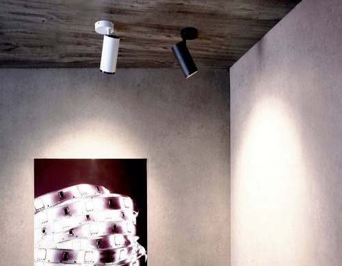 Dva stropné reflektory osvetľujú stenu s umeleckým dielom zobrazujúcim filmové kotúče. Scéna je navrhnutá moderne a minimalisticky.