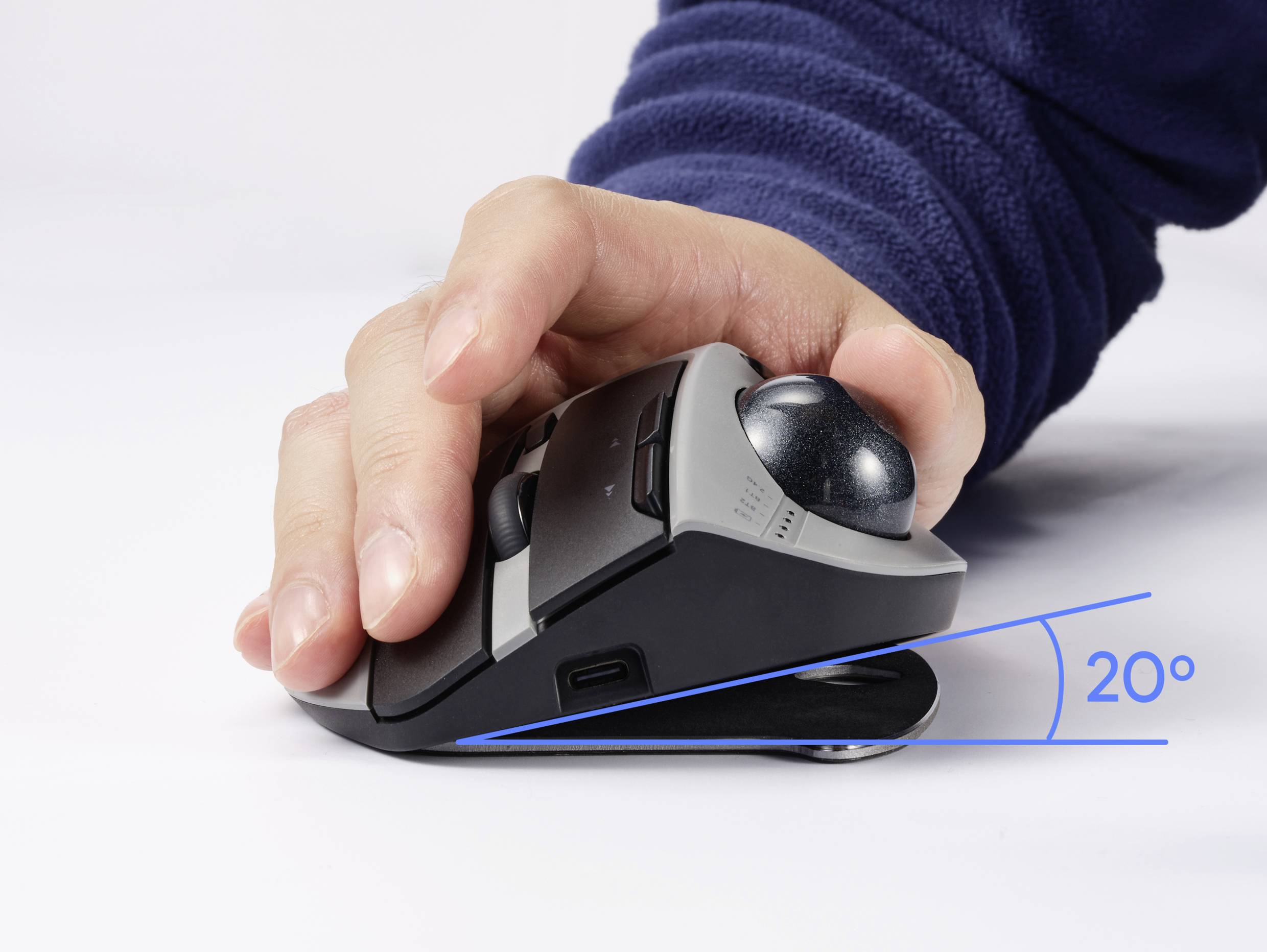 Ruka obsluhuje ergonomickú trackball myš so 20-stupňovým sklonom. Podporuje prirodzenú polohu ruky pre zníženie námahy.