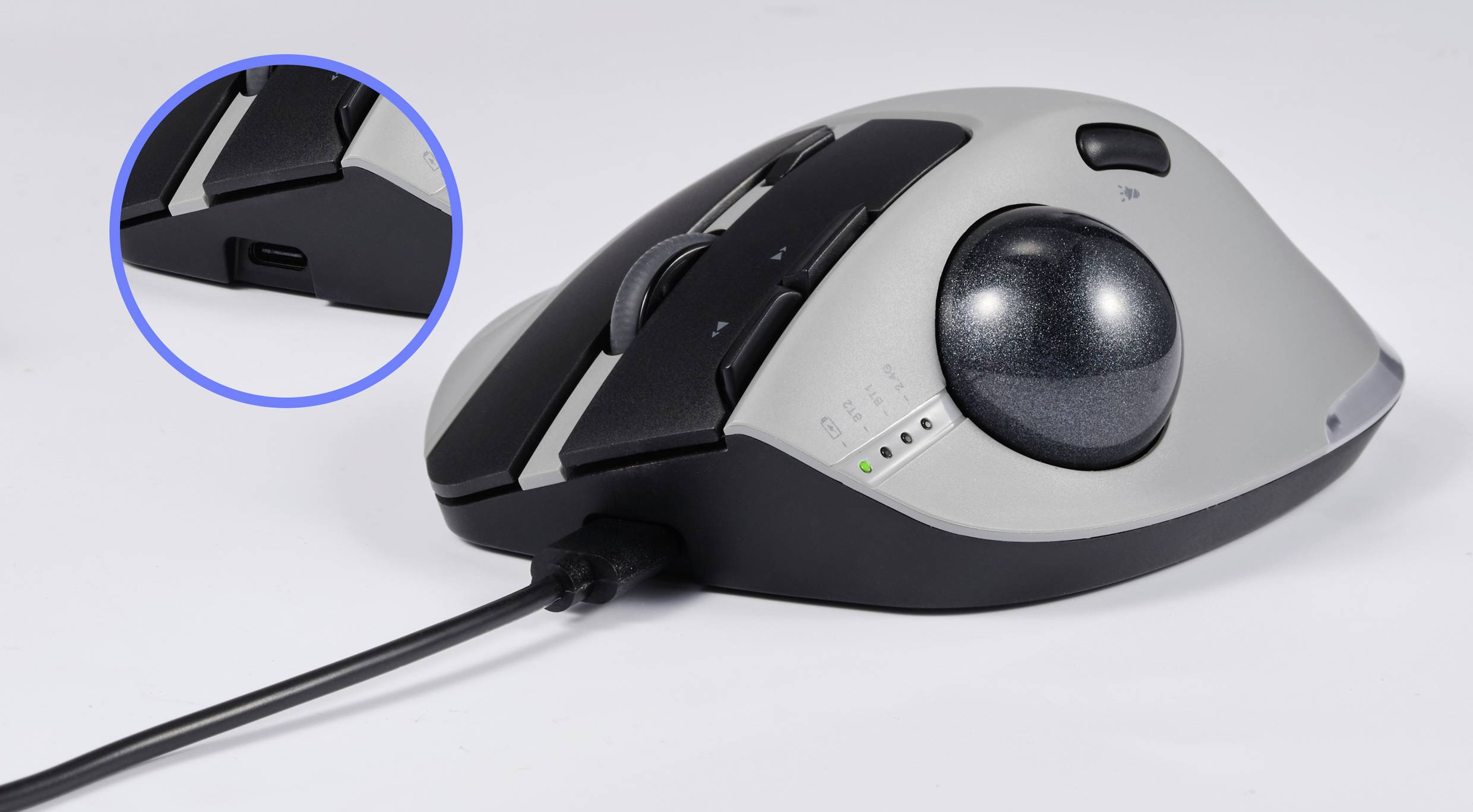 Káblová ergonomická počítačová myš s trackballom, s čiernym a sivým krytom, a detailným záberom USB konektora.