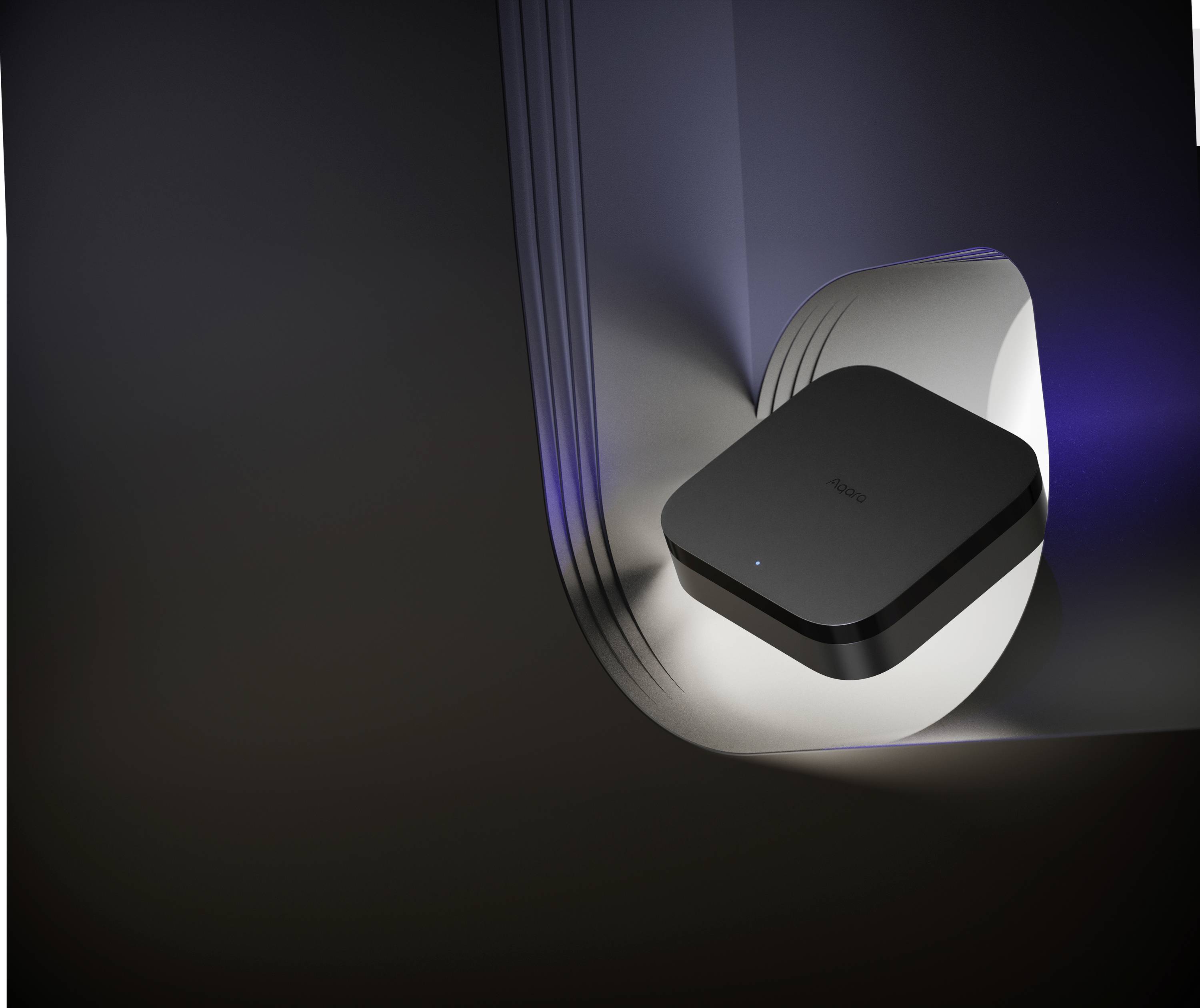 Čierne, obdĺžnikové zariadenie v futuristickom, zakrivenom púzdre, osvetlené modrými akcentmi.