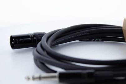 Čierne XLR kábel s jackom a XLR konektorom na bielom pozadí.