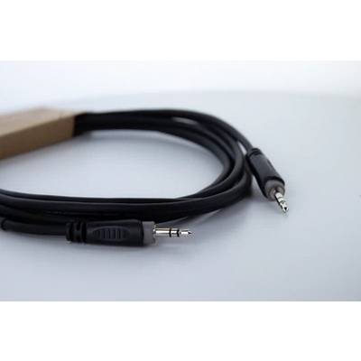 Čiernobiely audiokábel s dvoma 3,5 mm jack konektormi na svetlom povrchu.