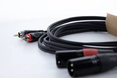Čierne audio káble s červeno-čiernymi konektormi na bielom pozadí.